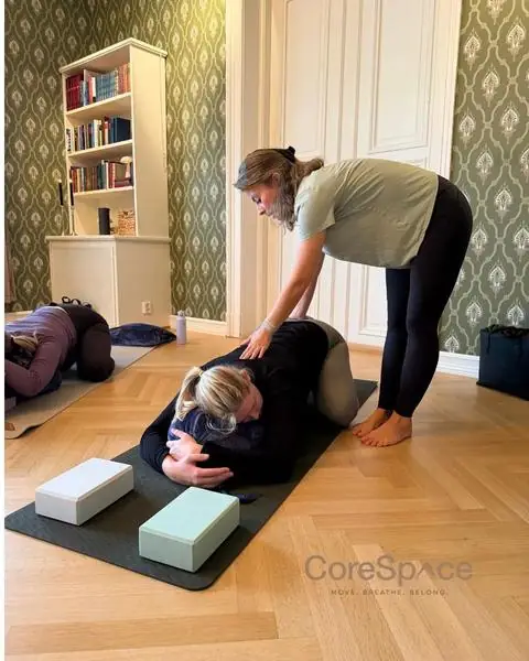 Sara justerer en gravid deltaker i barnestilling